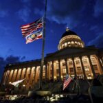 Charlie Kirk supporters Thomas Hess and Nolan Jenson stand in front of the Utah Capitol with flags to honor him,, Sept. 10, 2025.